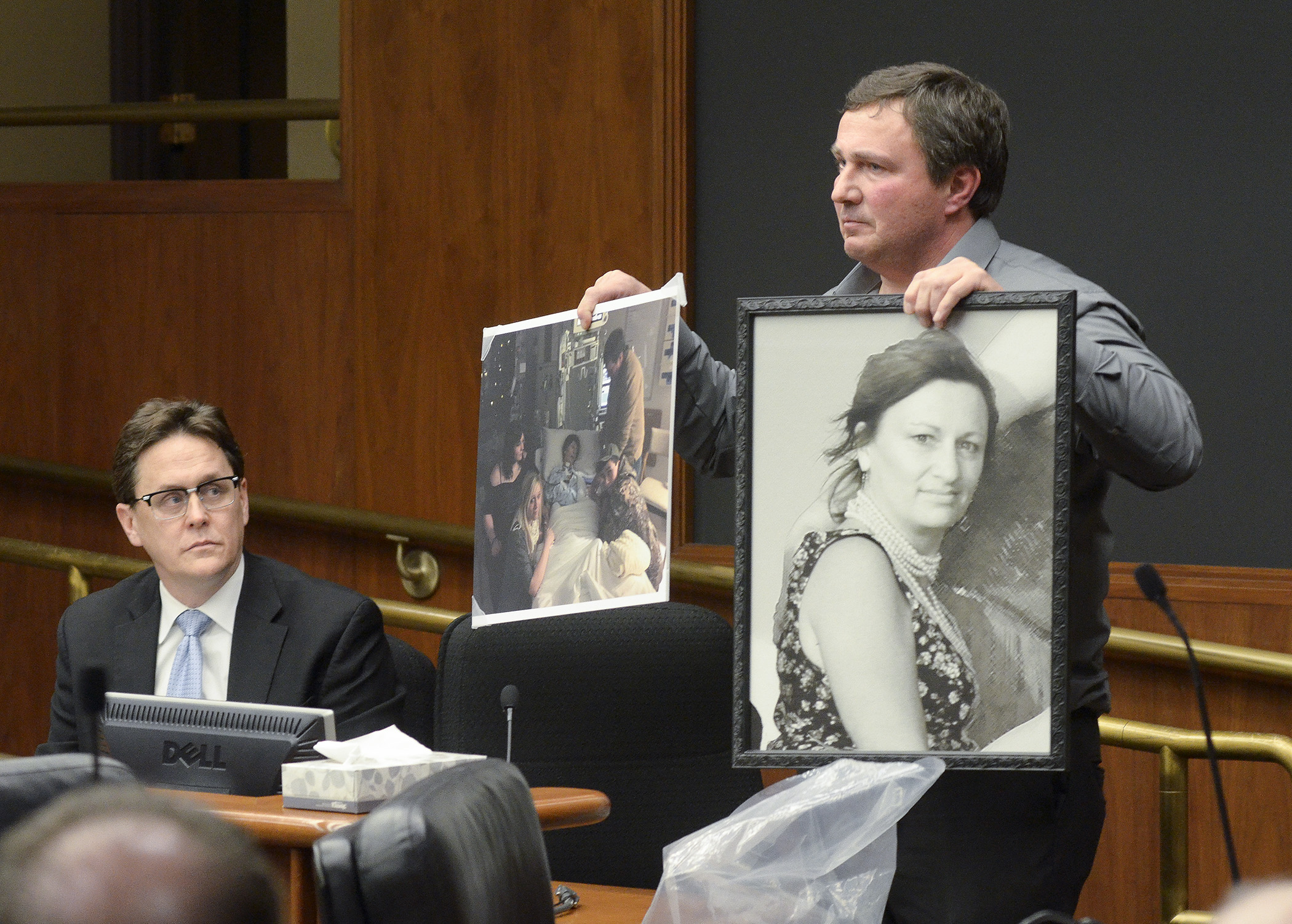 Chuck Dunker shows photos of his wife, Gail, who died of cancer on Jan. 9, 2015, during testimony for a bill sponsored by Rep. Matt Dean, left, to require Minnesota to transition to a federally facilitated health insurance exchange. Photo by Andrew VonBank